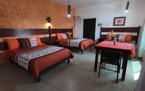 Cette chambre d'hôtel comprend 2 lits, une table et une table. dans l'établissement Kali Huasteca Posada, à Ciudad Valles