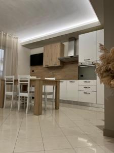 a kitchen with a wooden table and white cabinets at Casa Pati in Montescaglioso