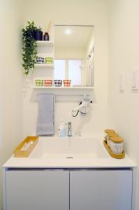 uma casa de banho branca com um lavatório e um espelho em Nagasaki - House / Vacation STAY 63873 em Nagasaki