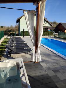 uma piscina com um gazebo e uma banheira de hidromassagem em Villa Čančar em Grabovac