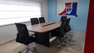 a wooden table with black chairs in a room at Special HOEStel in Monterrey! in Monterrey