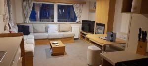 a living room with a couch and a tv at 58 Newquay View, Newquay Bay Resort in Porth