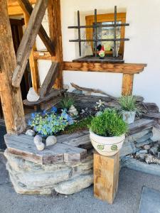 a porch with flowers and plants on the side of a house at Almhütte zwei Welten in Obervellach