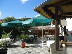 eine Terrasse mit Tischen, Stühlen und Sonnenschirmen in der Unterkunft Hotel-Restaurant Marcus in Malchin