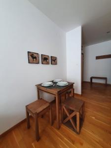Habitación con mesa de madera, mesa y sillas. en PLANINSKO JUTRO - Brzeće Centar Apartments, Kopaonik, en Brzeće