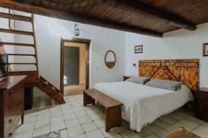 a bedroom with a bed and a table and a tv at Baglio Calia in Mazara del Vallo