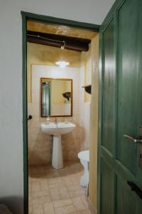 a bathroom with a sink and a mirror and a toilet at Baglio Calia in Mazara del Vallo +21 photos