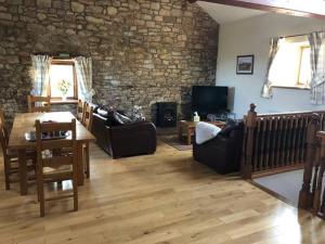 a living room with a stone wall at Sycamore Cottage in Appleby