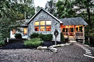 a stone house with a front porch and a driveway at Cherry Ridge Retreat Luxury Cabins 