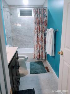 a bathroom with a shower and a toilet and a sink at Thompson House Cape Cod in South Yarmouth