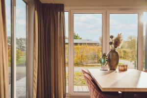 comedor con mesa y ventana grande en Tiny Cabin with Hottub I 4 p, en Rijssen
