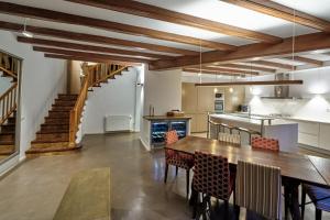 a kitchen with wooden ceilings and a table and chairs at The Corner House of Altafulla - A Stroll from the Beach, in the Heart of the Old Town in Altafulla