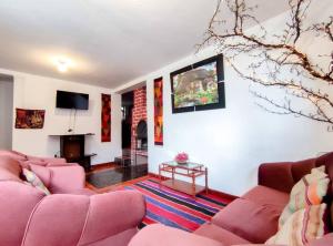sala de estar con sofás rosados y TV en GRAN CASA de vacaciones; 15min plaza principal a pie, en Cusco
