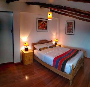 1 dormitorio con 1 cama y 2 mesitas de noche con lámparas en GRAN CASA de vacaciones; 15min plaza principal a pie, en Cusco