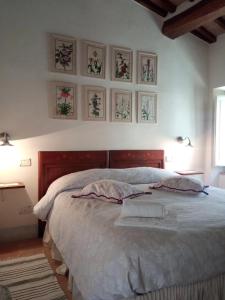 a bedroom with a bed with four pictures on the wall at Casa Demo in Fighine