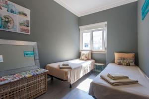 um pequeno quarto com 2 camas e uma janela em Be Local - Apartment with 2 bedrooms in Moscavide - Lisbon em Lisboa