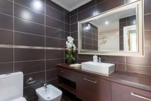 a bathroom with a toilet and a sink and a mirror at Be Local - Apartment with 2 bedrooms in Moscavide - Lisbon in Lisbon