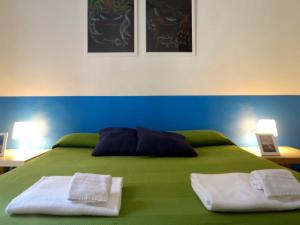 Una cama verde con dos toallas encima. en Gianluca's Room, en Catania