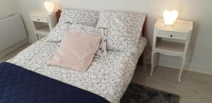 a bed in a room with two night stands and two tables at Maison entre relooking et modernité dans un cadre verdoyant pour amoureux de grands espaces in Nogent-sur-Vernisson