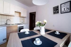 kuchnia ze stołem z krzesłami i wazonem kwiatów w obiekcie Urban Nest Apartments Szewska 21-19 w Krakowie