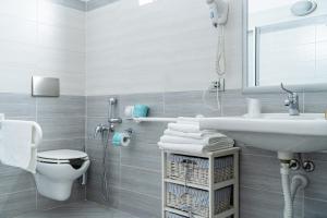 a white bathroom with a sink and a toilet at Agriturismo Ortesida in Morbegno