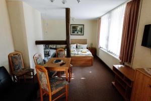a room with a bed and a table and chairs at Pension Kristall in Elbingerode