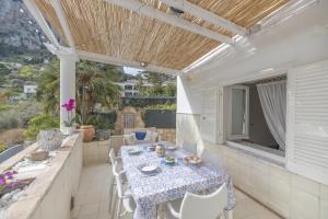 a patio with a table and chairs on a balcony at Capri center holidays in Capri