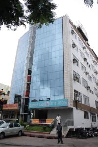 dos hombres parados frente a un edificio en Hotel Roopa, en Mysore