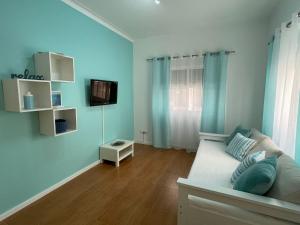 a living room with a couch and a tv at Blue Home Monte Gordo in Monte Gordo