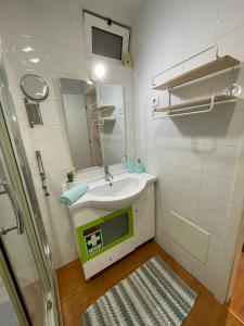a small bathroom with a sink and a mirror at Blue Home Monte Gordo in Monte Gordo