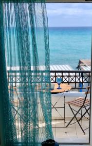 a view of the ocean from a balcony with a table and chair at Sagma calm apartment with amazing sea view in Perissa