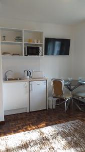 ein Wohnzimmer mit einem Tisch und einer Mikrowelle in der Unterkunft O Cantinho do Sol (Estúdio Chocolate) in Lourinhã