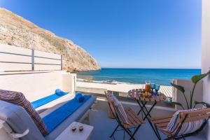 a patio with a table and chairs and the ocean at Sagma calm apartment with amazing sea view in Perissa