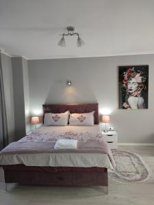 ein Schlafzimmer mit einem großen Bett und zwei Lampen in der Unterkunft Flora Apartment in Surčin