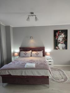 a bedroom with a large bed and two lamps at Flora Apartment in Surčin