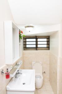 Un baño con un inodoro blanco y un lavabo. en Baldwin Beauty House, en Accra 24 fotos más