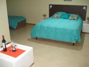 um quarto com uma cama e uma mesa com uma garrafa de vinho em Akimekedo em Mendoza
