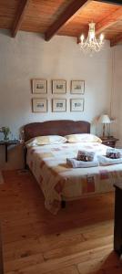 a bedroom with a large bed and a chandelier at CASA DA POUPARIÑA in Deveso