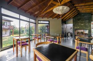 um restaurante com mesas e cadeiras e uma lareira em Arcano Casa Montaña em Villa La Angostura