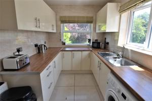a kitchen with white cabinets and a sink and a window at Small single bed in Oxford