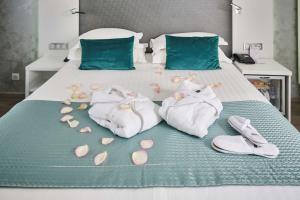 アヌシーにあるベスト ウエスタン プラス ホテル カールトン アヌシーのベッド(タオル、靴、花付)