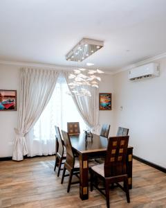 uma sala de jantar com mesa e cadeiras em Baldwin Beauty House em Accra