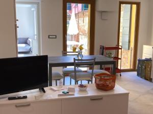 een woonkamer met een tafel en een televisie bij Appartamento Tre Archi con corte privata in Venetië