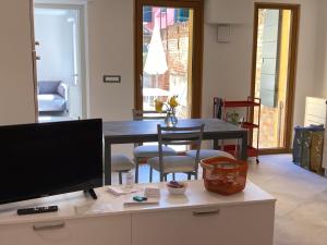 a living room with a table and a television at Appartamento Tre Archi con corte privata in Venice