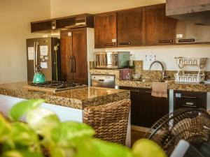 a kitchen with wooden cabinets and a counter top at Villa Bonobo in Puerto Escondido