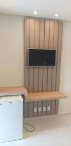 a room with a wall with a tv and a shelf at Hotel Pousada da Lapa in Bom Jesus da Lapa