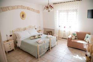 una camera da letto con un letto, un divano e una sedia di Dimora Aia Piccola ad Alberobello