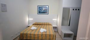 a small room with a bed and a refrigerator at Hotel Zeus Lido di Classe Room Only in Lido di Classe