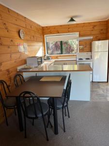 a kitchen with a table and chairs in a room at Cedarwood Lakeside Motel & Conference Venue in Rotorua