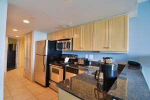 a kitchen with stainless steel appliances and wooden cabinets at Fabulous Ocean Front Penthouse Condo, OO Resort, 21st Fl in Myrtle Beach +39 photos